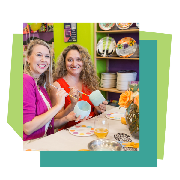 Two women painting ceramic items at a bridal shower at As You Wish pottery studio.